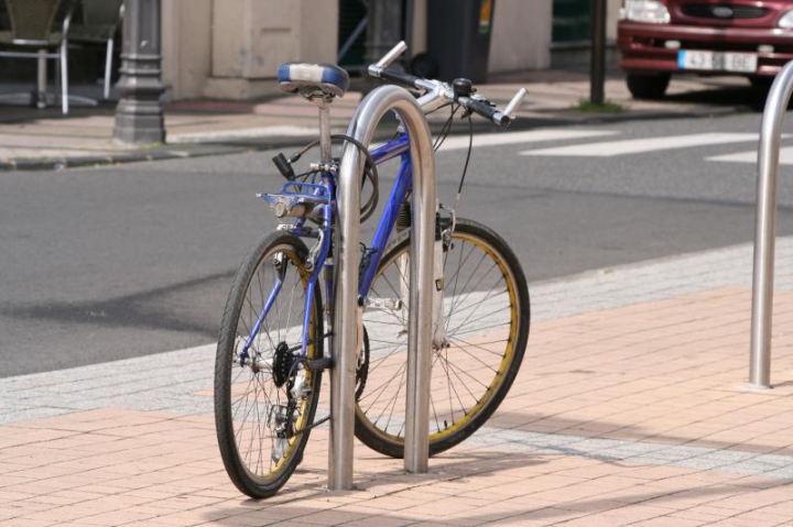 Vélo attaché à un arceau de sécurité installé sur un trottoir